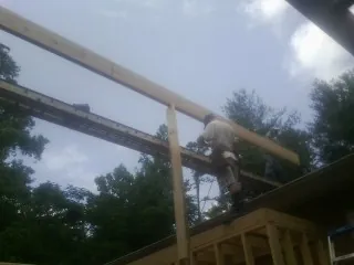 Carpenter setting a ridge beam over a new addition frame — Ice Dam Removal by Roofing Brothers in Burbank