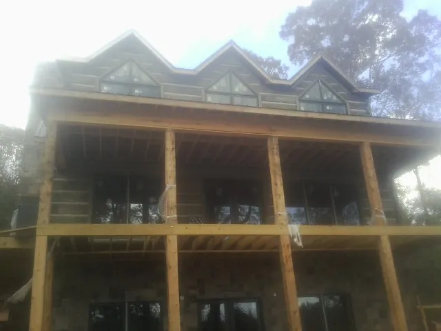 Dormers and porch framing on a large log home under construction — Roof Coating work by our crew in Burbank